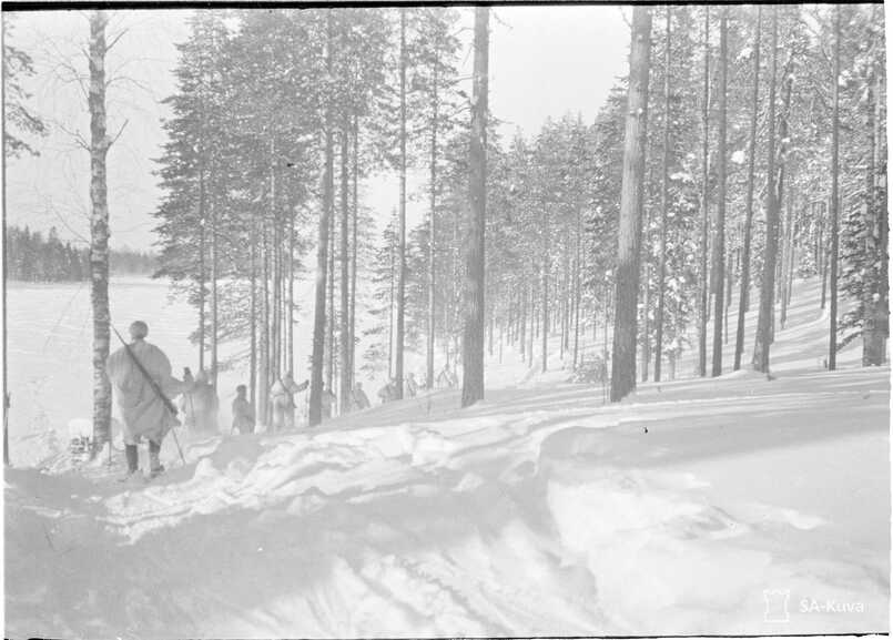 Sotilaita hiihtää metsässä talvisodan aikana.